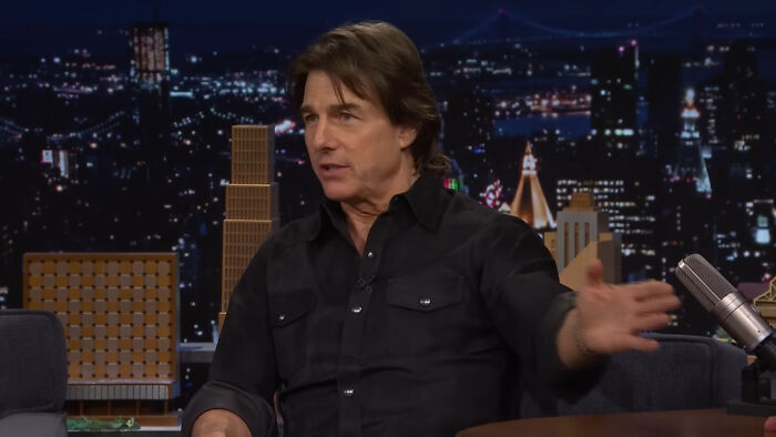 Actor in a black shirt speaking on a late-night talk show set discussing Hollywood hypocrisy about aging trends.