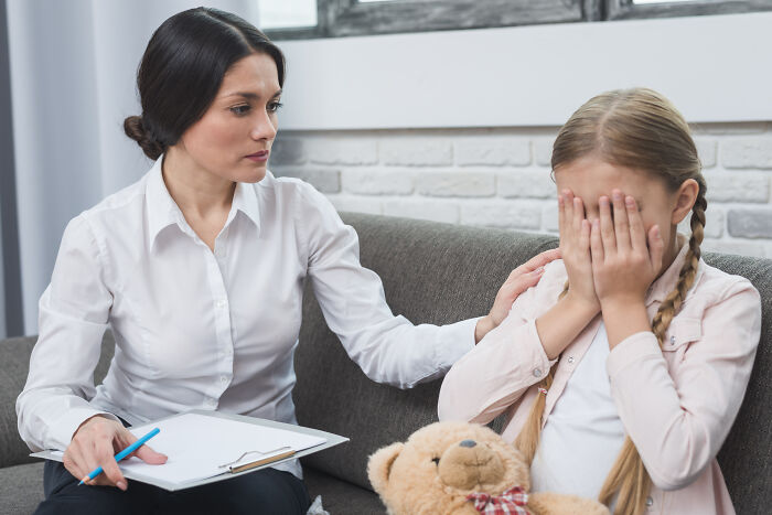 Therapist comforting upset young girl during a counseling session, highlighting emotional moments shared by therapists.