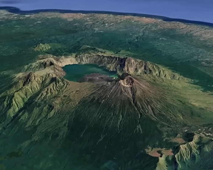 Aerial view of an active volcano with a crater lake, illustrating the site where a tourist was trapped inside the volcano.