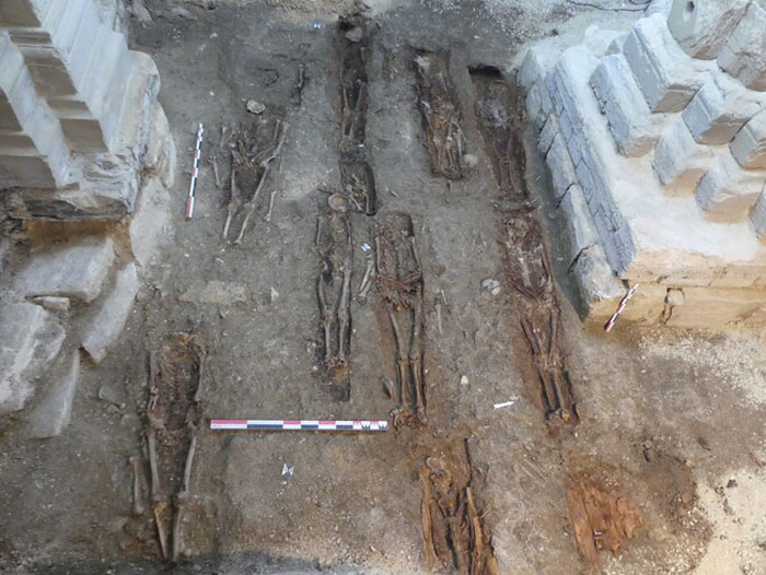 Skeletons of a 400-year-old burial vault uncovered during archaeological excavation at church restoration site.