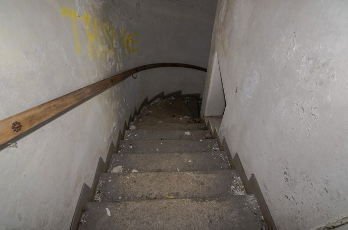 Stone staircase leading down to a 400-year-old burial vault discovered during church restoration works with debris on steps.