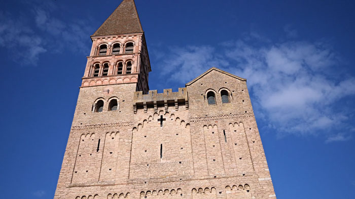 Historic stone church tower under blue sky where 400-year-old burial vault was discovered during restoration works.