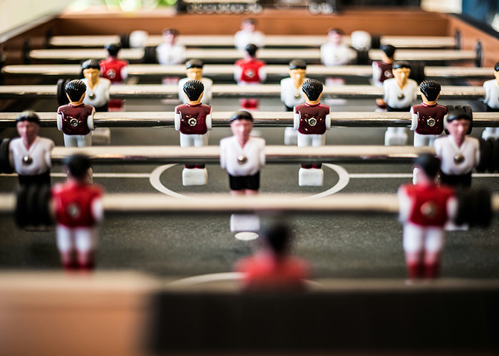 Foosball table with red and white players lined up in a game, highlighting fun moments shared by parents about kids.