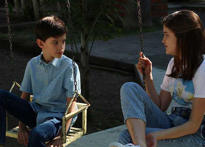 Two kids sitting on swings outside, sharing funny and inappropriate things kids have blurted out.