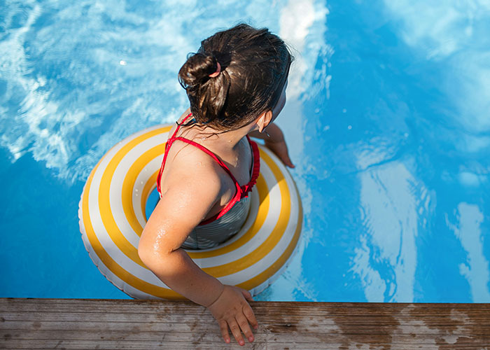 Child wearing a swim ring in a pool, capturing funny and inappropriate things kids have blurted out by parents.