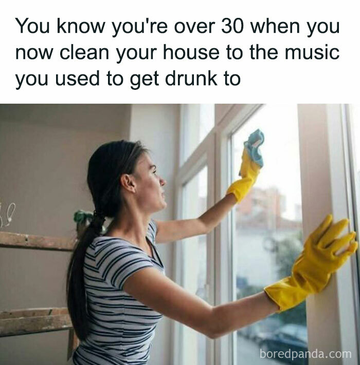 Woman wearing yellow gloves cleaning a window, illustrating a funny post about getting older and sharing humor online.
