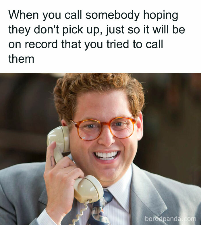 Man in glasses and suit smiling while holding a phone, illustrating relatable human experience meme concept.