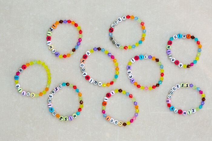 Colorful beaded bracelets with letter beads spelling words, illustrating creativity related to younger generations' abilities.