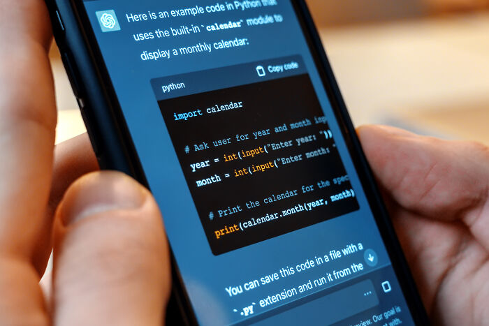 Smartphone screen showing Python code with a calendar module, illustrating teachers sharing horror stories about younger generations' skills.