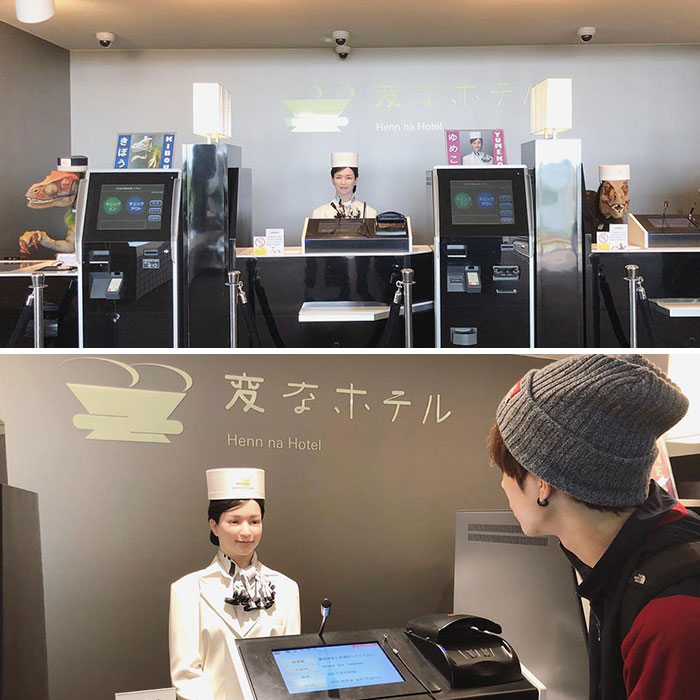 Robot receptionist with dinosaur heads behind counters at a uniquely designed hotel front desk area.