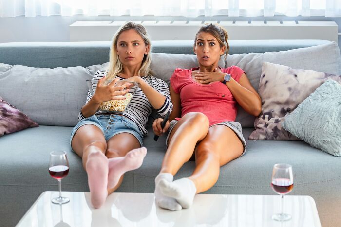 Two women watching TV with concerned expressions, reflecting a good trend slowly disappeared in entertainment choices.