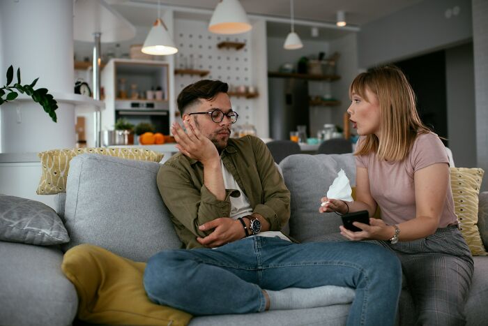 Couple in a tense conversation on a couch, highlighting moments that drove away potential life partners.