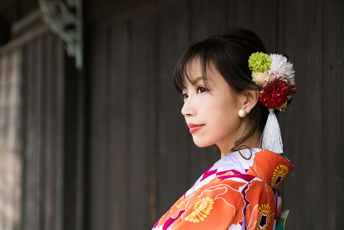 Young woman in traditional kimono with floral hair accessories, representing foreigners experiencing life big in Japan.