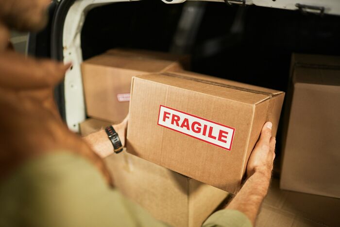 Person holding a fragile box revealing sneaky things found by people who read terms and conditions carefully.