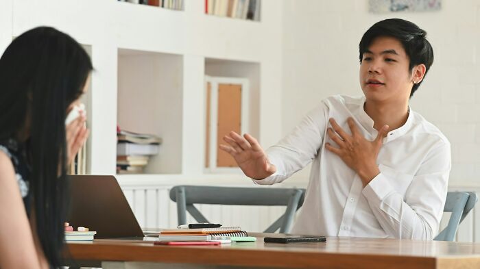 Woman appearing frustrated during a conversation with a dismissive doctor in a clinical office setting.