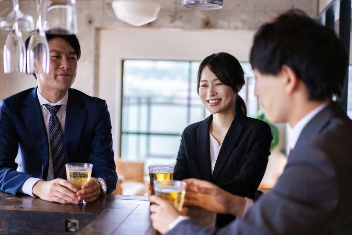 Three professionals enjoying drinks and discussing the shortcomings of being big in Japan in real life.