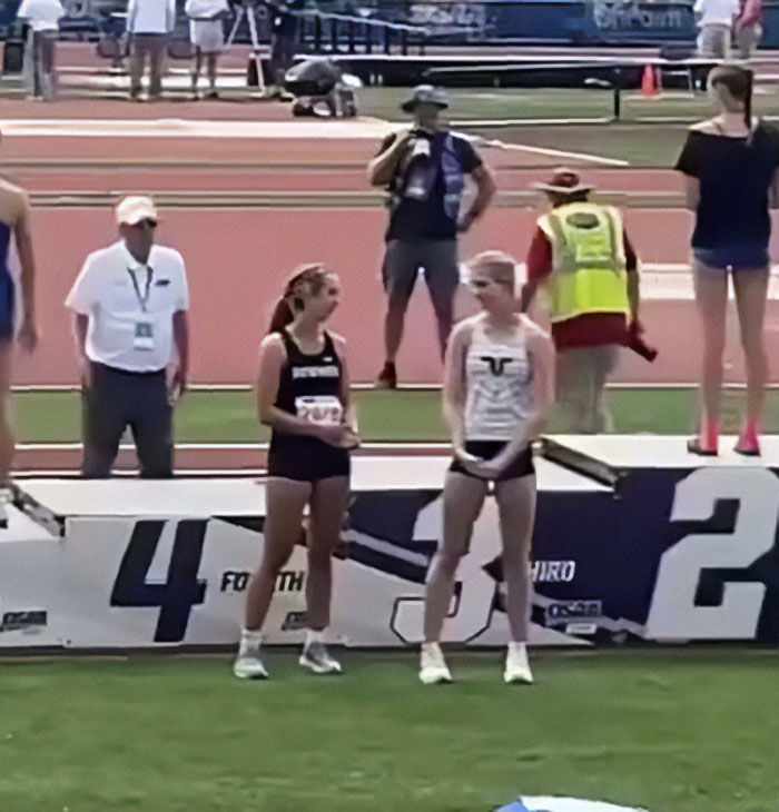 Transgender athlete standing near podium after winning 5th place as cisgender rivals refuse to share the podium. Transgender athlete standing near podium after winning 5th place as cisgender rivals refuse to share the podium.