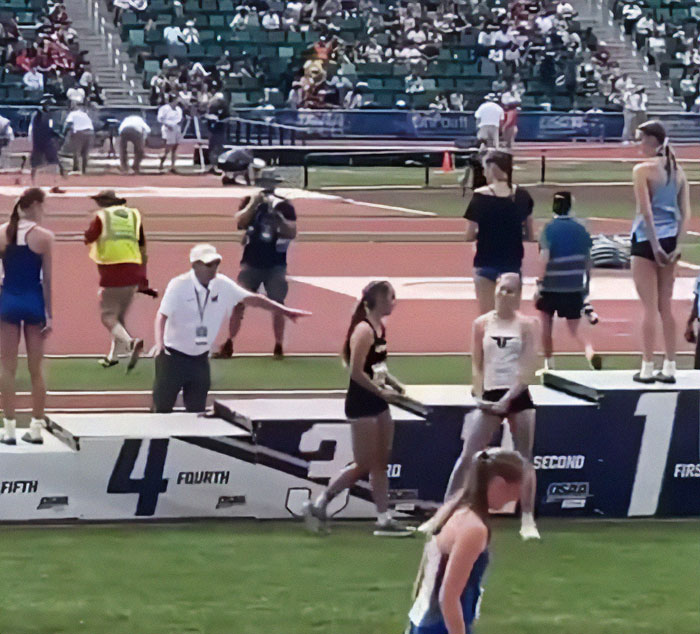 Track and field podium showing transgender athlete standing off the main platform after cisgender rivals refuse to share podium space. Track and field podium showing transgender athlete standing off the main platform after cisgender rivals refuse to share podium space.