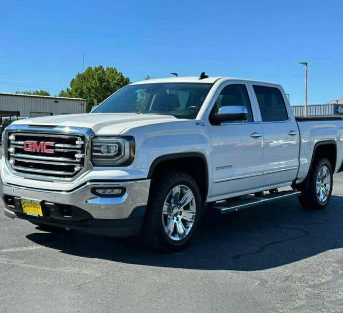 White GMC pickup truck parked outdoors on asphalt under clear blue sky, related to tragic cause of passing of 3 sisters.