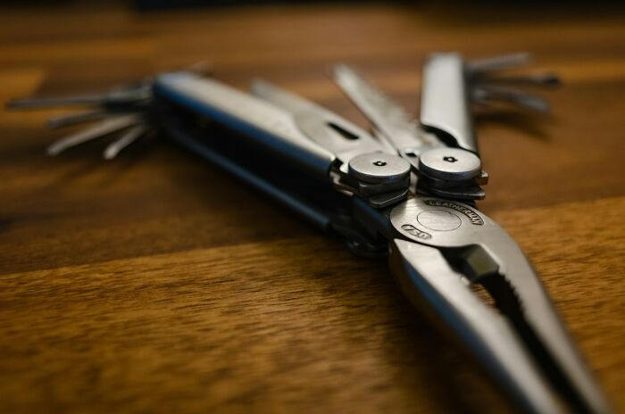 Multitool pliers lying on a wooden surface, one of the everyday items under $300 that dramatically improved lives.