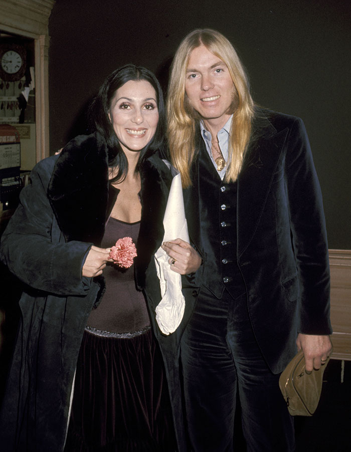Cher smiling with a man, wearing a dark outfit, related to news about alleged kidnap attempt and son's overdose.