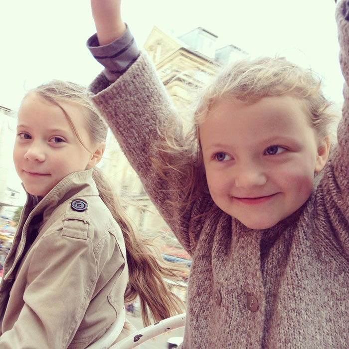 Two young girls smiling outdoors, highlighting Greta Thunberg's singer sister who changed name after backlash.