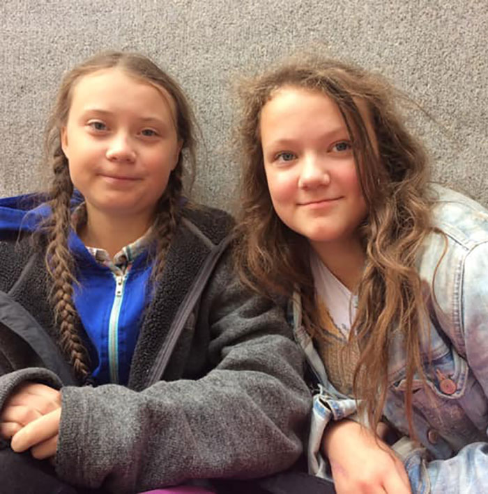 Two young women sitting side by side, one with braided hair, representing Greta Thunberg&rsquo;s singer sister after backlash.