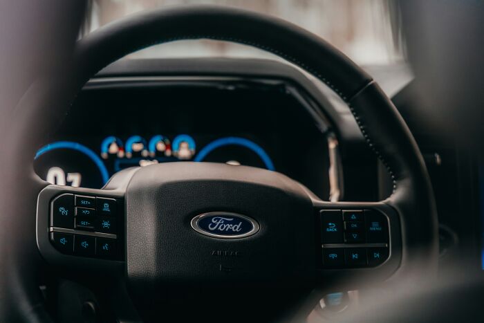 Close-up of a Ford steering wheel inside a car, illustrating companies that crashed due to key person knowledge loss.