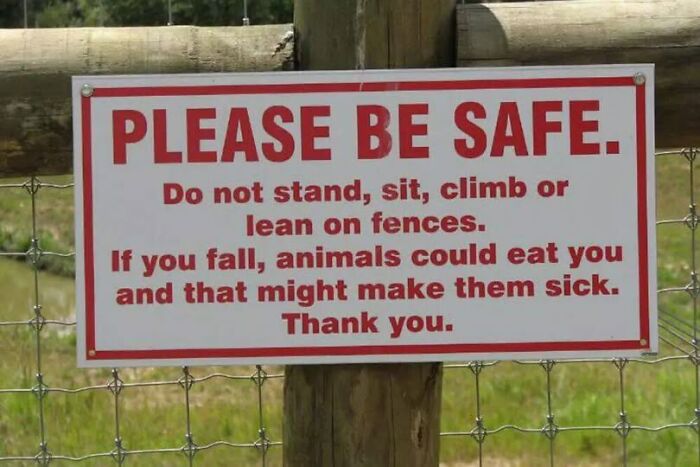 Humorous safety sign warning not to climb fences to avoid animals eating visitors and causing chaos.