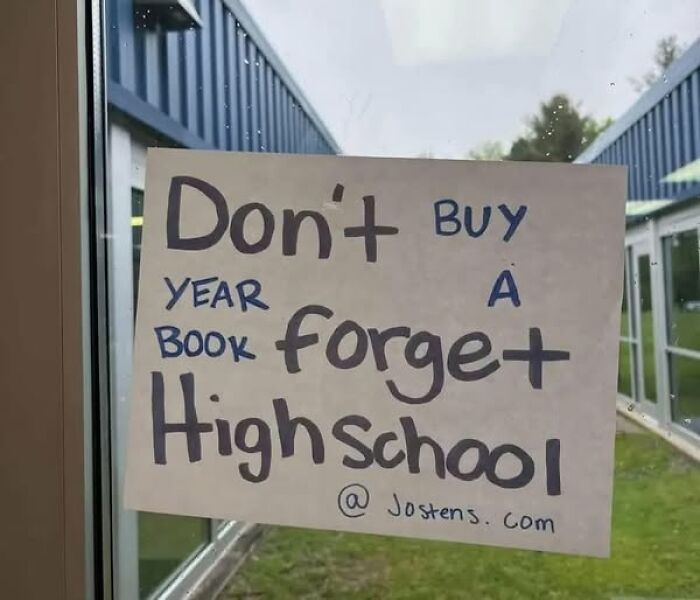 Handwritten sign with a confusing message about not buying a high school yearbook, adding chaos and humor.