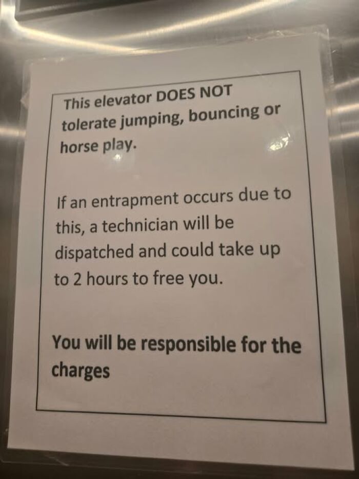 Sign in an elevator warning against jumping or horseplay, mentioning technician rescue and potential charges for chaos.