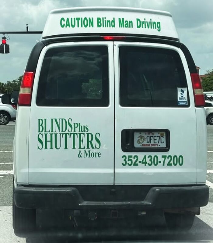 Van with sign saying CAUTION Blind Man Driving and business logo Blinds Plus Shutters highlighting hilarious signs adding chaos.