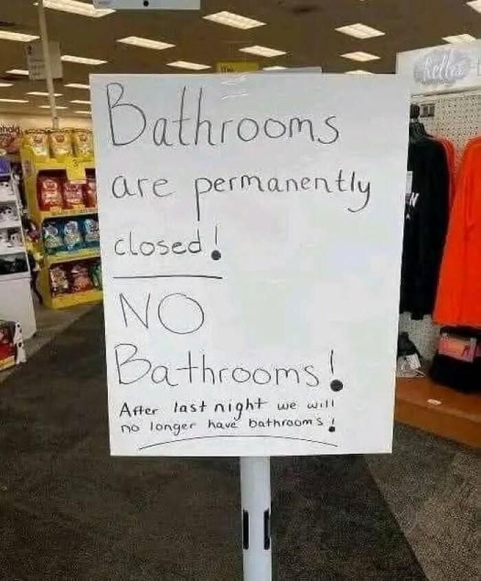 Handwritten sign in store announcing bathrooms are permanently closed, adding humor and chaos to the world.