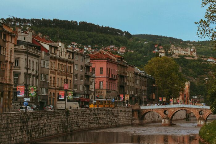 Old historic cityscape with river and stone bridge, illustrating folks from history people would love to call.