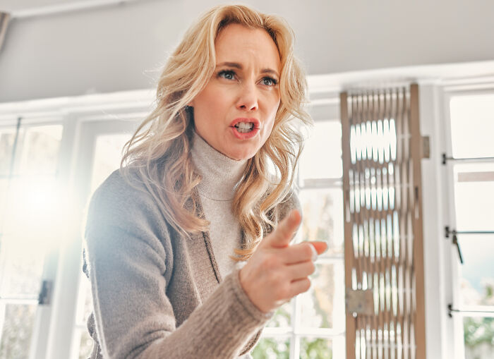 Woman expressing concern and frustration indoors, illustrating emotions related to postpartum OCD experiences.