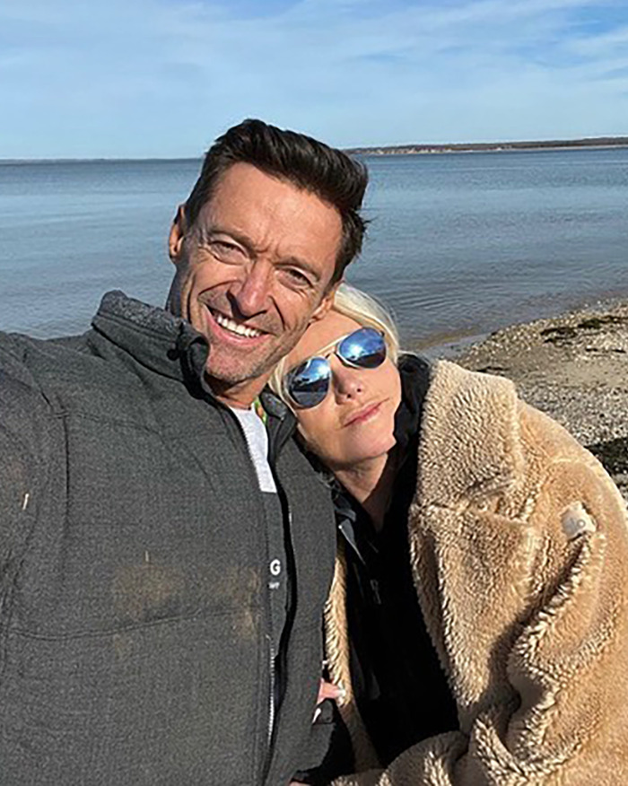 Hugh Jackman and Sutton Foster outdoors by the water, smiling and wearing warm jackets in casual selfie. Hugh Jackman and Sutton Foster outdoors by the water, smiling and wearing warm jackets in casual selfie.