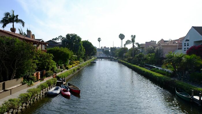 Canals with small boats lined by houses and palm trees, showing something totally normal in a country that may shock Americans