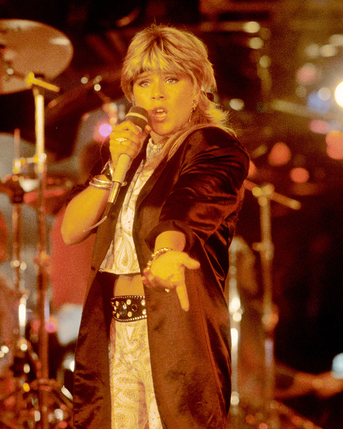 Pop star performing on stage in 80s style, captivating fans with a sizzling and iconic look.