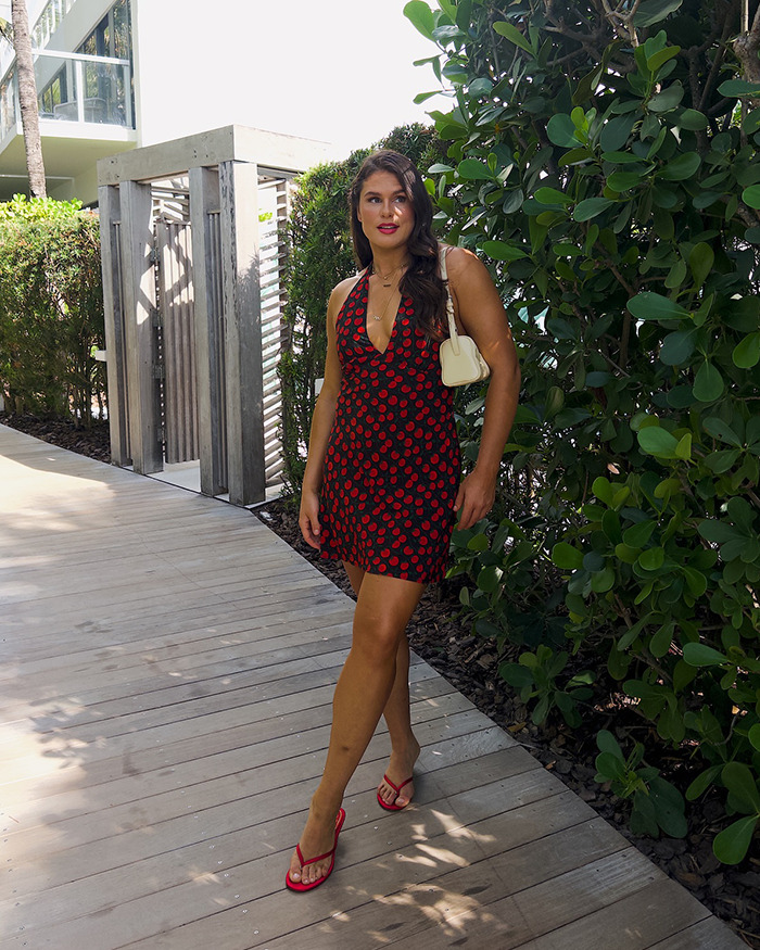 Woman confidently walking outdoors in summer dress, relating to Olympic star walking runway on her period discussion. Woman confidently walking outdoors in summer dress, relating to Olympic star walking runway on her period discussion.