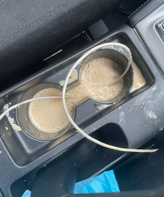 Spilled coffee in car cup holders with a tangled wire, illustrating damage caused by careless people borrowing items.