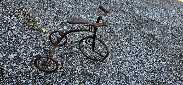 Rusty vintage tricycle found outdoors, an unexpected thing discovered in walls and hidden places in homes.