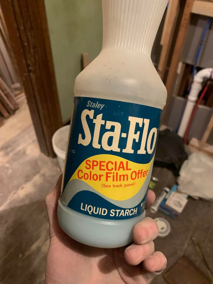 Hand holding a vintage liquid starch bottle found in walls and other hidden places in people’s homes.