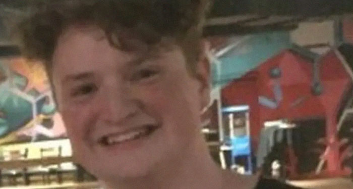 Smiling young man with curly hair in a casual indoor setting, related to today I learned brain facts concept.