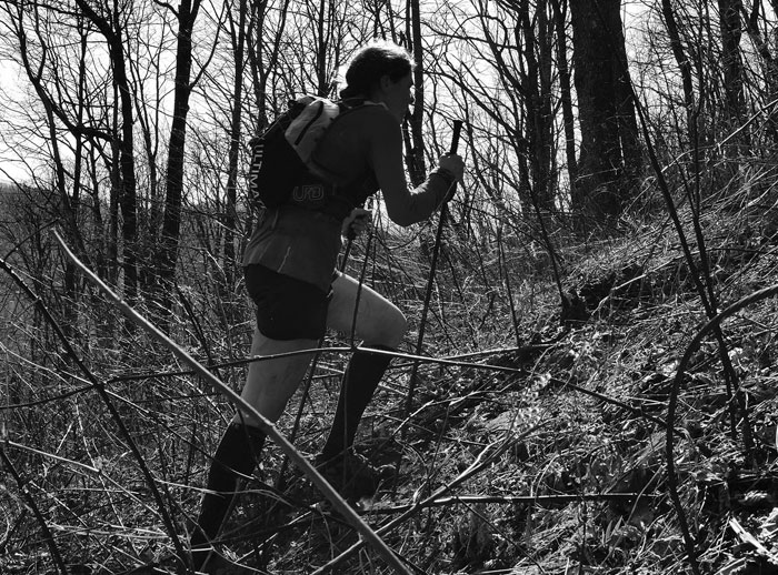 Person hiking uphill in a forest, illustrating active lifestyle to keep the brain healthy and active outdoors.