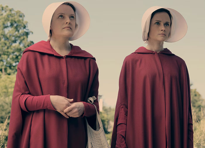 Two women in red cloaks and white bonnets stand outdoors, linking to brain healthy facts and keeping the brain active.