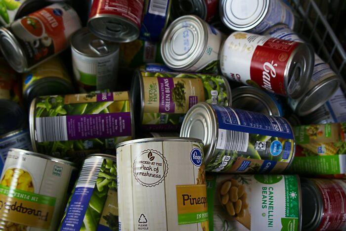 A pile of canned foods including green beans and pineapple, illustrating creative ways people got back at cheating exes.