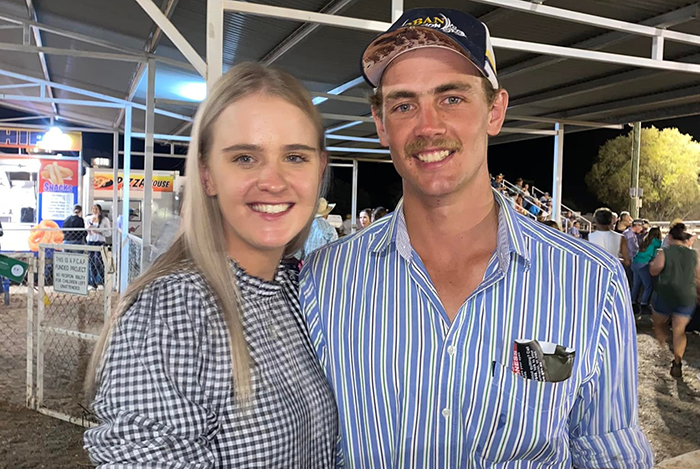 Young woman and man smiling together at an outdoor event, related to woman who set male friend on fire case.