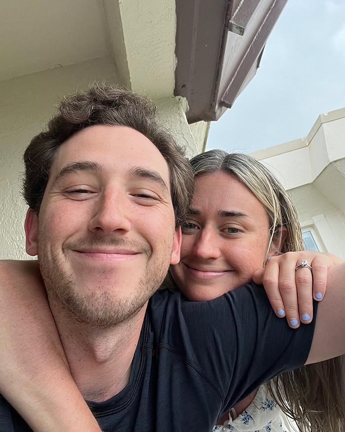 Young couple smiling close up, embracing outside near a building, newlyweds on honeymoon before tragedy in ankle-deep water.