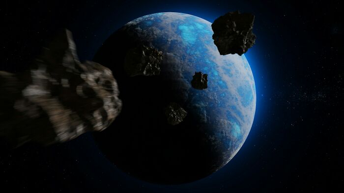 Asteroids approaching a blue planet in space representing the asteroid impact linked to dinosaur extinction facts.