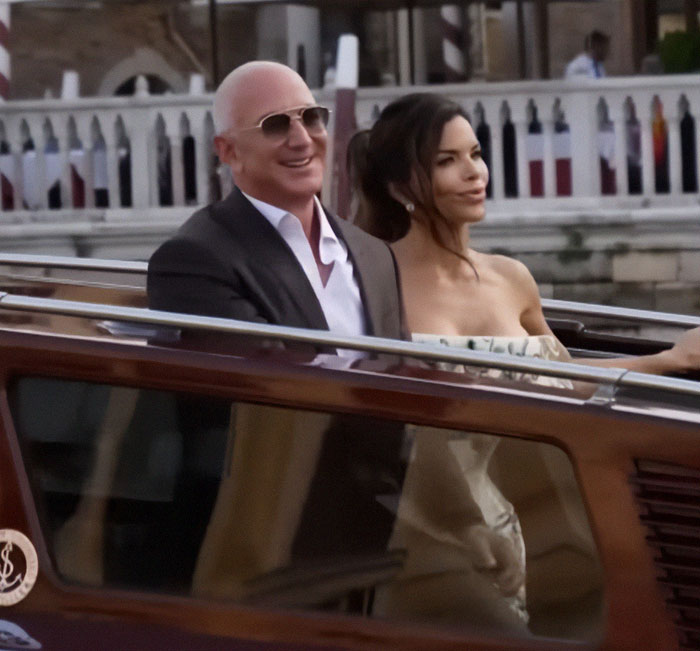 Jeff Bezos and Lauren S&aacute;nchez arriving by boat, captured in a candid moment at a high-profile wedding event.
